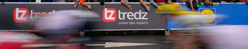 A mountain biker jumping on a trail in loamy woodland